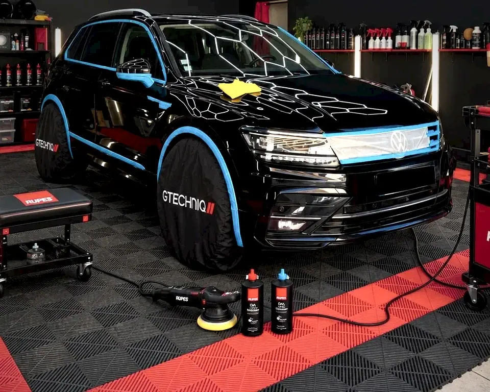 SUV noir masqué avant polish, polisseuse et produits de correction à l'atelier